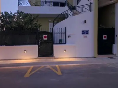 a building with a gate with lights on it at Vicky's place,near Athens airport in Koropíon