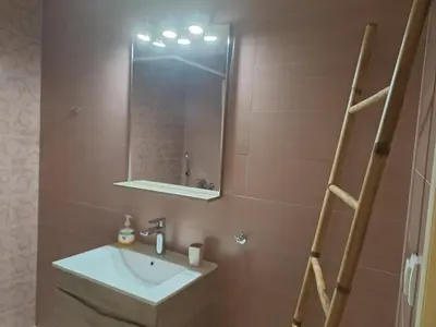 a bathroom with a sink and a mirror at Vicky's place,near Athens airport in Koropíon