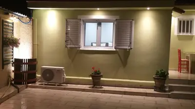 a room with a window and a tv on a wall at Vicky's place,near Athens airport in Koropíon