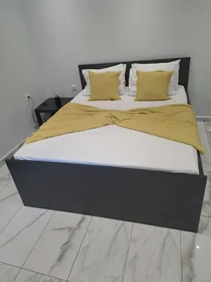 a bedroom with a large bed with a black headboard at Vicky's place,near Athens airport in Koropíon