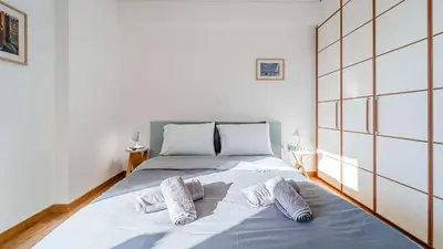 a bedroom with a bed with two pillows on it at Piraeus Bright Apt in Piraeus