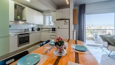 a kitchen with a wooden table with a vase of flowers on it at Piraeus Bright Apt in Piraeus