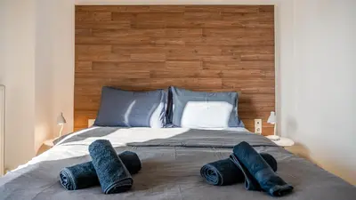 a bed with a large wooden headboard and some pillows at Piraeus Bright Apt in Piraeus