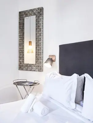a bedroom with a bed with a mirror and a table at Art Pantheon - Suites & Apartments in Athens