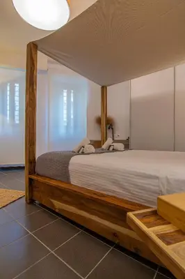a bedroom with a large bed with a wooden frame at Art Pantheon - Suites & Apartments in Athens