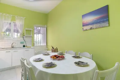 a dining room with a table and chairs and a kitchen at Casa Bonita, House with Private Entrance and Garden, between center and sea in Athens