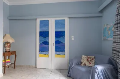 a living room with a door and a chair at Casa Bonita, House with Private Entrance and Garden, between center and sea in Athens