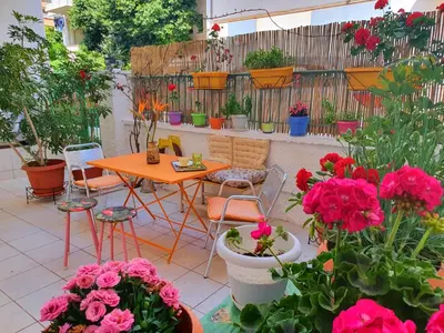 a patio with a table and chairs and flowers at Casa Bonita, House with Private Entrance and Garden, between center and sea in Athens