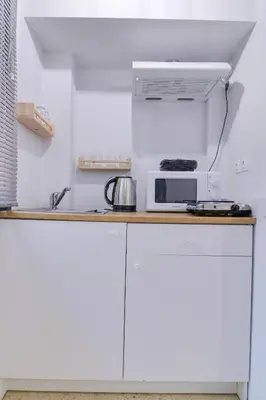 a kitchen with white cabinets and a microwave at athens.apartotel.2 in Athens