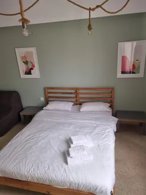a bedroom with a bed with white sheets and towels at athens.apartotel.2 in Athens