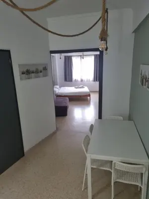a living room with a table and a bed at athens.apartotel.2 in Athens
