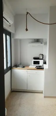 a kitchen with white cabinets and a microwave on a counter at athens.apartotel.2 in Athens