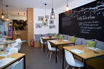 a restaurant with tables and chairs and a chalkboard at A little Taste of Home Apartments in Athens