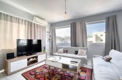 a living room with a couch and a television at A little Taste of Home Apartments in Athens