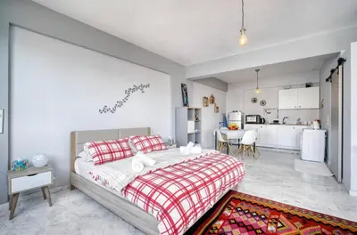 a bedroom with a large bed and a kitchen at A little Taste of Home Apartments in Athens