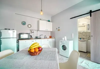 a kitchen with a table with a basket of fruit on it at A little Taste of Home Apartments in Athens