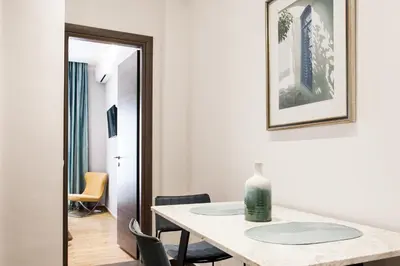 a room with a table and chairs and a mirror at Nicholas Point Apartments and Rooms in Athens