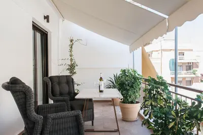 a balcony with chairs and a table and plants at Nicholas Point Apartments and Rooms in Athens