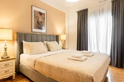 a bedroom with a bed with two towels on it at Nicholas Point Apartments and Rooms in Athens