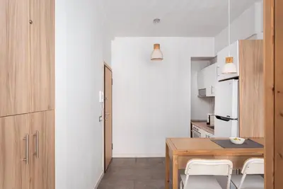 a kitchen with a wooden table and white cabinets at Acropolis Cozy Living in Athens