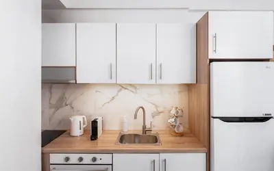 a kitchen with white cabinets and a sink at Acropolis Cozy Living in Athens