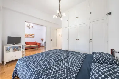 a bedroom with a blue bed and a tv at The Athenian Apartment in Athens