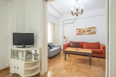 a living room with a couch and a tv at The Athenian Apartment in Athens