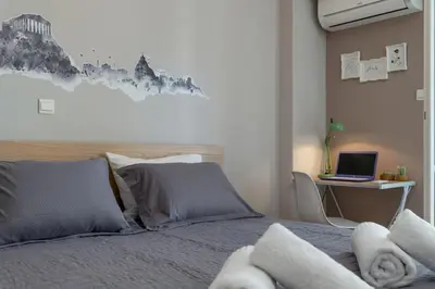a bedroom with a bed and a desk with a laptop at Eleana Apartment By The Acropolis in Athens