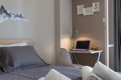 a bedroom with a bed and a desk with a laptop at Eleana Apartment By The Acropolis in Athens