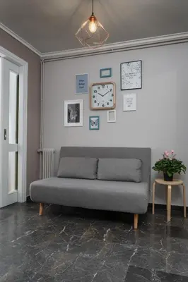 a living room with a couch and a clock on the wall at Eleana Apartment By The Acropolis in Athens