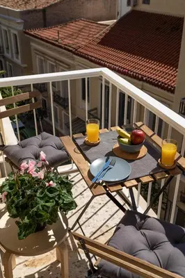 a table with fruits and vegetables on a balcony with orange juice at Eleana Apartment By The Acropolis in Athens