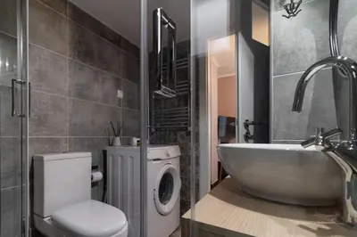 a bathroom with a tub and a toilet and a sink at Eleana Apartment By The Acropolis in Athens