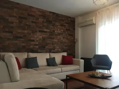 a living room with a couch and a brick wall at Villa Christina with private pool in Saronida, near stunning beaches, Athens airport & Sounio in Saronida