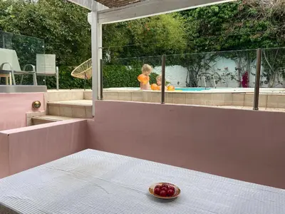 a bowl of fruit on a table with a child in a pool at Villa Christina with private pool in Saronida, near stunning beaches, Athens airport & Sounio in Saronida