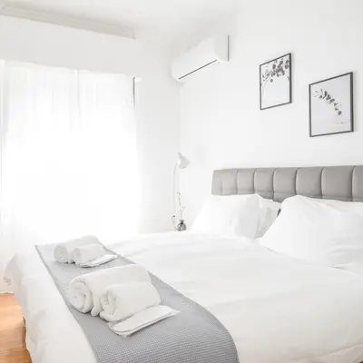 a white bedroom with white towels on a bed at Modern design apartment near Acropolis 2 in Athens