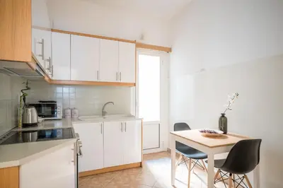 a kitchen with white cabinets and a table and chairs at Modern design apartment near Acropolis 2 in Athens
