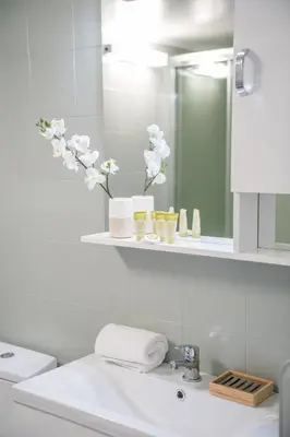 a white bathroom with a sink and a mirror at Modern design apartment near Acropolis 2 in Athens