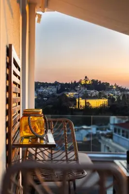 a table and chair on a balcony with a view of a city at The 1 and only Acropolis penthouse in Athens