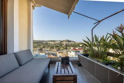 a couch and a table on a balcony with a view at The 1 and only Acropolis penthouse in Athens