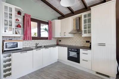 a white kitchen with white cabinets and appliances at The 1 and only Acropolis penthouse in Athens
