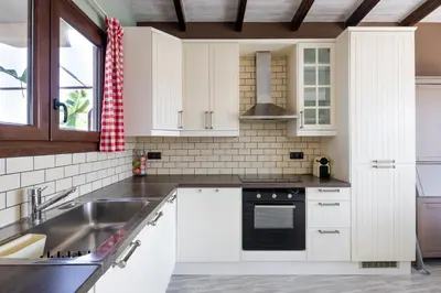 a kitchen with white cabinets and a sink at The 1 and only Acropolis penthouse in Athens