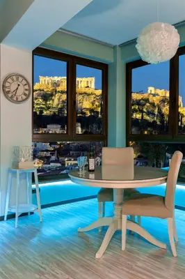 a dining room with a table and chairs and windows at The 1 and only Acropolis penthouse in Athens