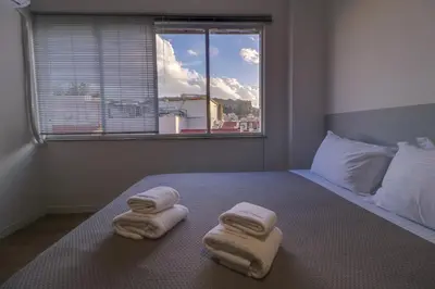 a bedroom with two towels on a bed with a window at apartotel.acropolis.view in Athens