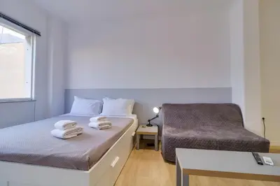 a bedroom with two beds and a chair at apartotel.acropolis.view in Athens
