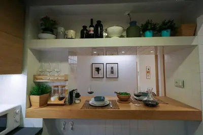 a kitchen with a counter with plates and wine glasses at Superior Central Apt|3min to Metro|AC|Netflix|iMac in Athens