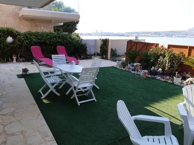 a patio with chairs and a table and grass at Nana's philoxenia in Porto Rafti