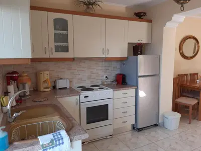 a kitchen with white cabinets and a white refrigerator at Nana's philoxenia in Porto Rafti