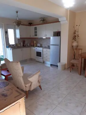 a kitchen with white appliances and a table and chairs at Nana's philoxenia in Porto Rafti
