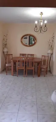 a dining room with a table and chairs and a mirror at Nana's philoxenia in Porto Rafti