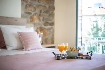 a tray with two glasses of orange juice on a bed at Ancient Agora Apartments in Athens